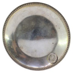 Silver tray w/ raised frieze on the edge w/ coat of arms on the smooth bottom