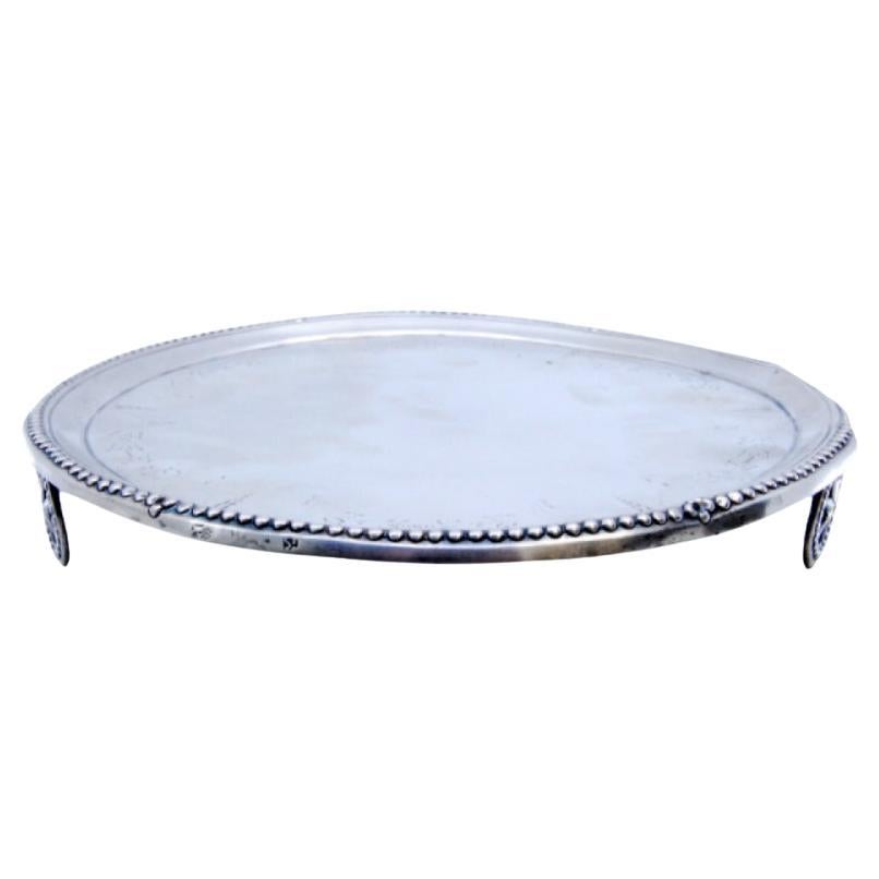 Silver tray with engravings, pearly rim and resting on three wheel-shaped feet