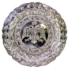 Silver tray with garlands, hanging bows and coat of arms in the center