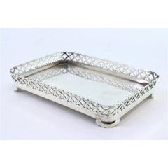 Silver tray with wire rack and smooth base resting on four cut-out feet
