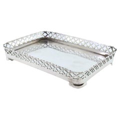 Silver tray with wire rack and smooth base resting on four cut-out feet