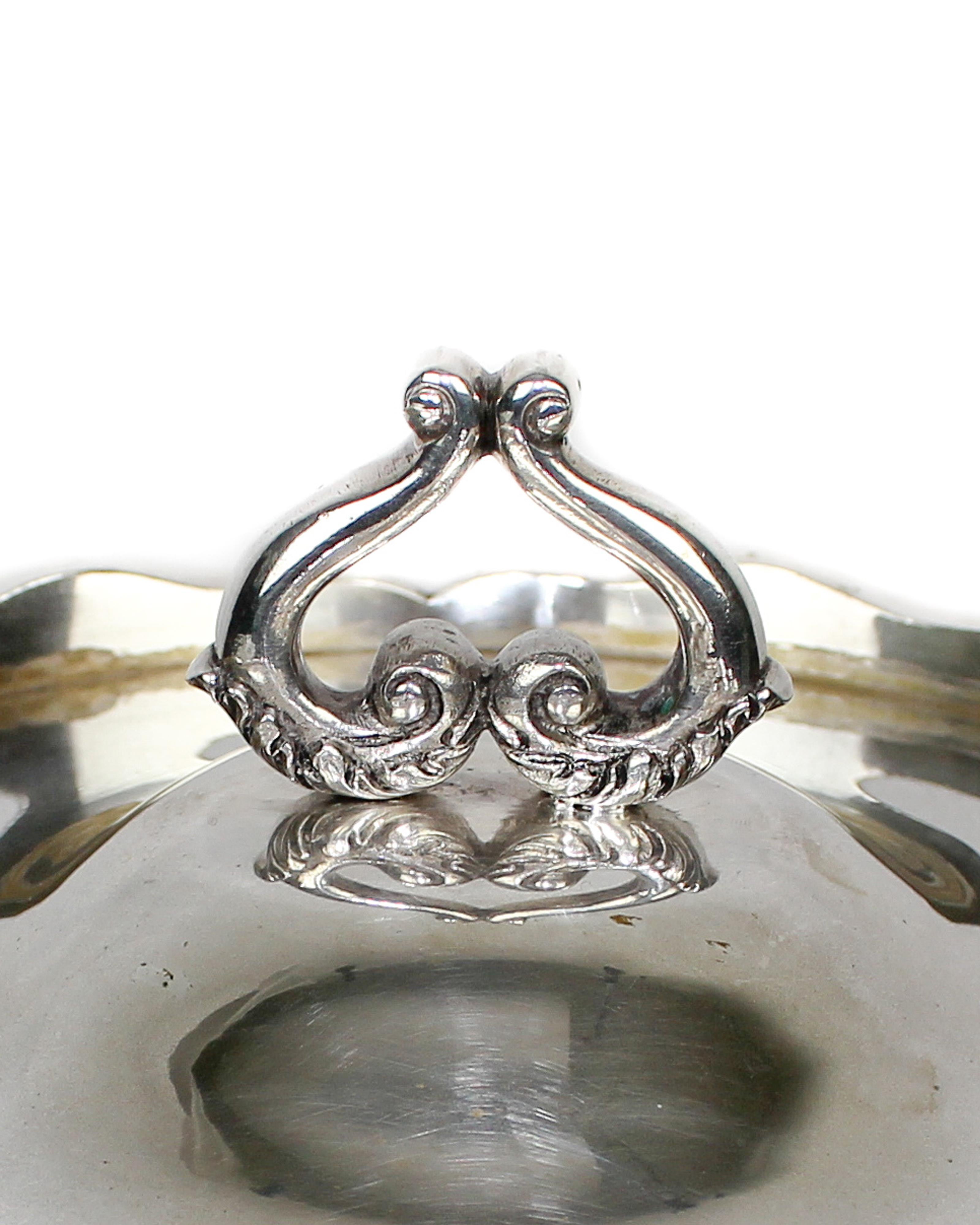 A Portuguese silver tureen from the 20th century. The cover knob it’s decorated with little volutes and vegetal motifs. Lisboa assay mark, Águia III, 833% (1938-1984). Maker's mark “Eloy Lisboa”.
    