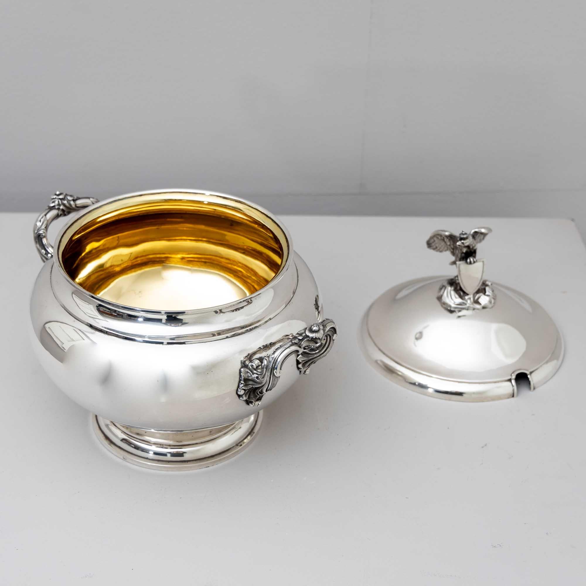 Large 750 silver lidded tureen by Maker Hermann Brückmann, with figurative crowned eagle holding a shield on a stylized landscape base. The handles are in rocaille form, the bulging wall is otherwise smooth. Total weight approx. 1680g.