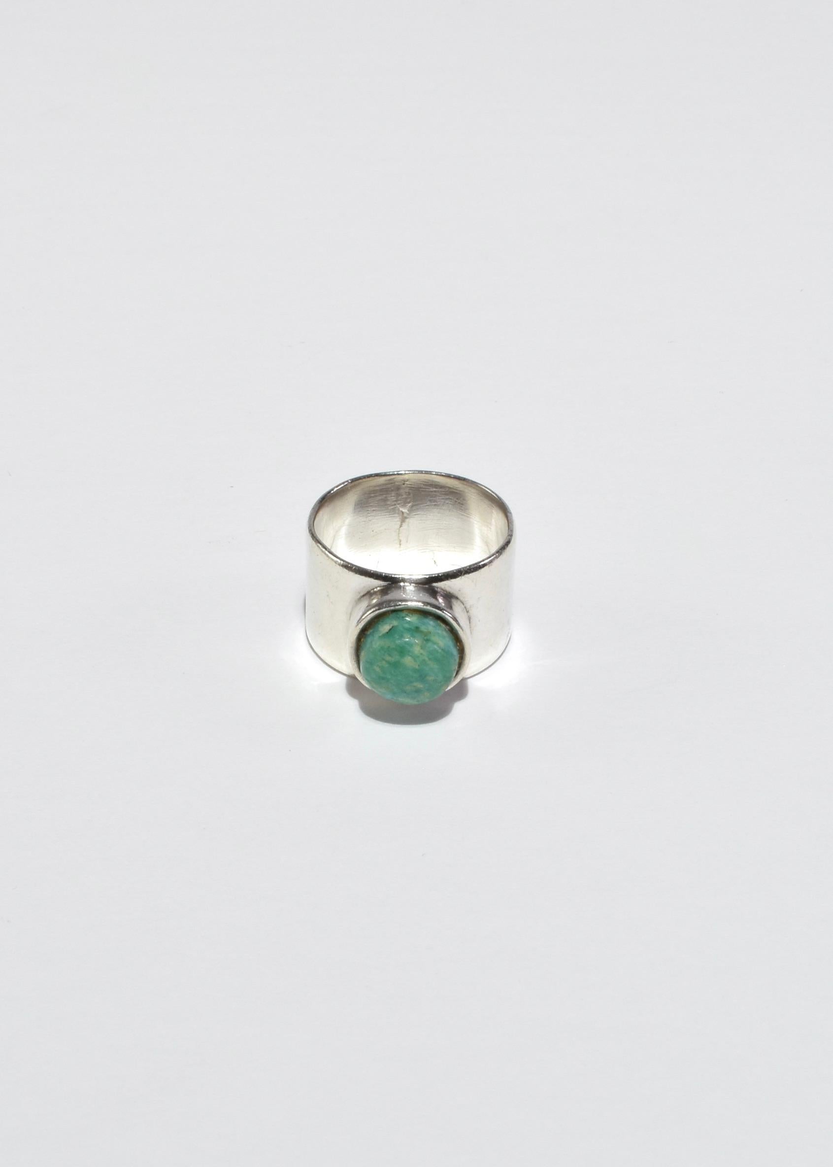 Vintage silver wide band ring with a round turquoise cabochon.

Material: Sterling silver, turquoise.