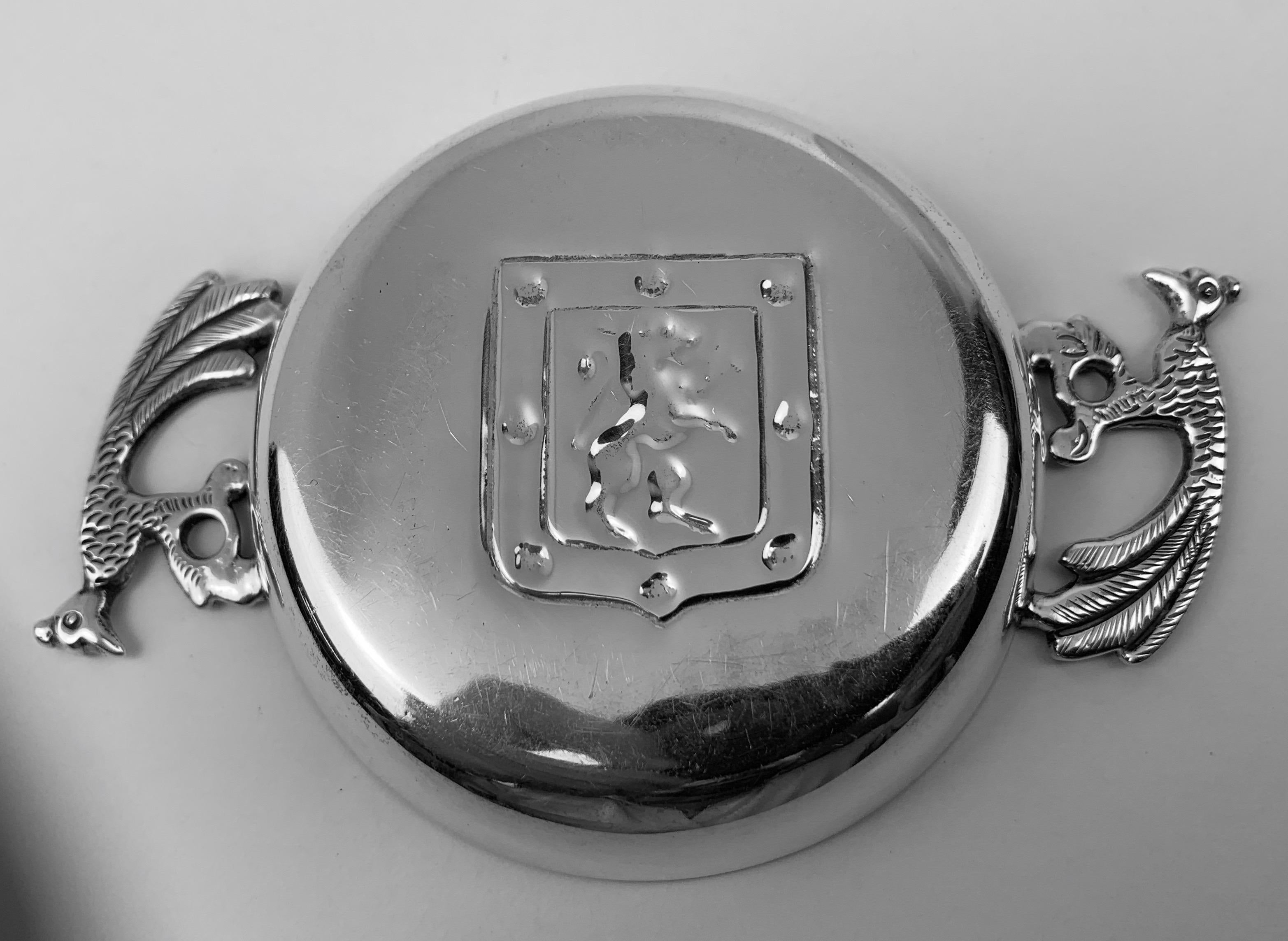 Vintage silver two handled tastevin. The handles are exotic birds and in the center of the tastevin there is a shield with a rampant lion.
Marked on the side .900 (silver) Chile. The perfect gift for a budding sommelier.