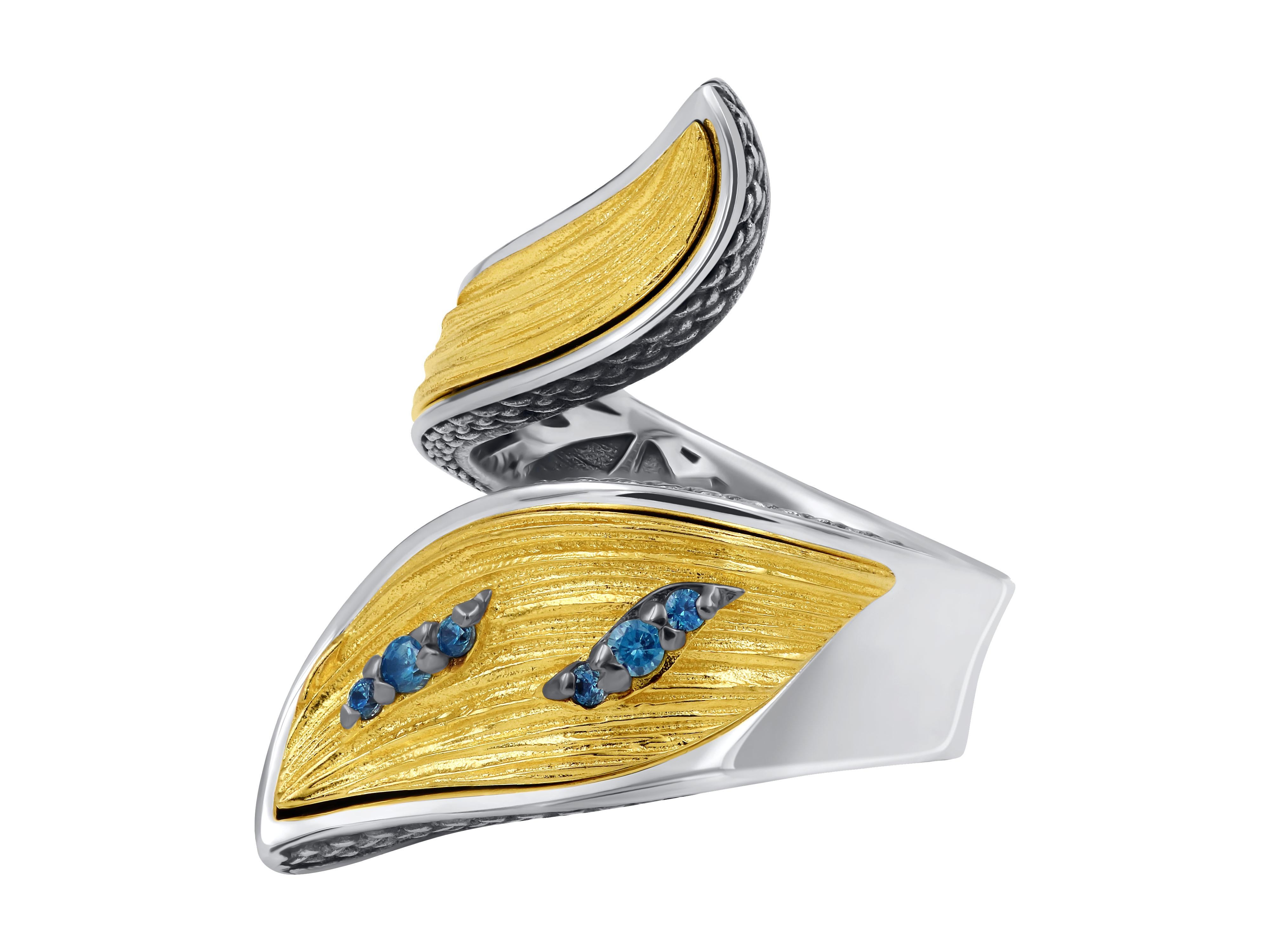A silver two-tone ring, with a gold-plated textured surface and a beautiful blue topaz gemstone, offers a unique and elegant design. The ring features a mix of silver and gold tones, creating a striking contrast that adds to its overall beauty.
The