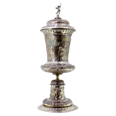 Silver urn with engravings 
Cupid-topped lid on round base