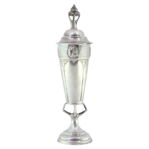 Silver urn with reliefs, cut-out handle on the lid and placed on a hollow base For Sale