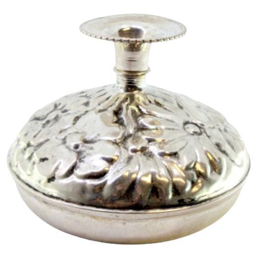 Silver vase with raised floral motifs and a circular base