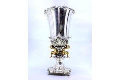 Silver vase with two children in relief in gold in the center supporting a dome
