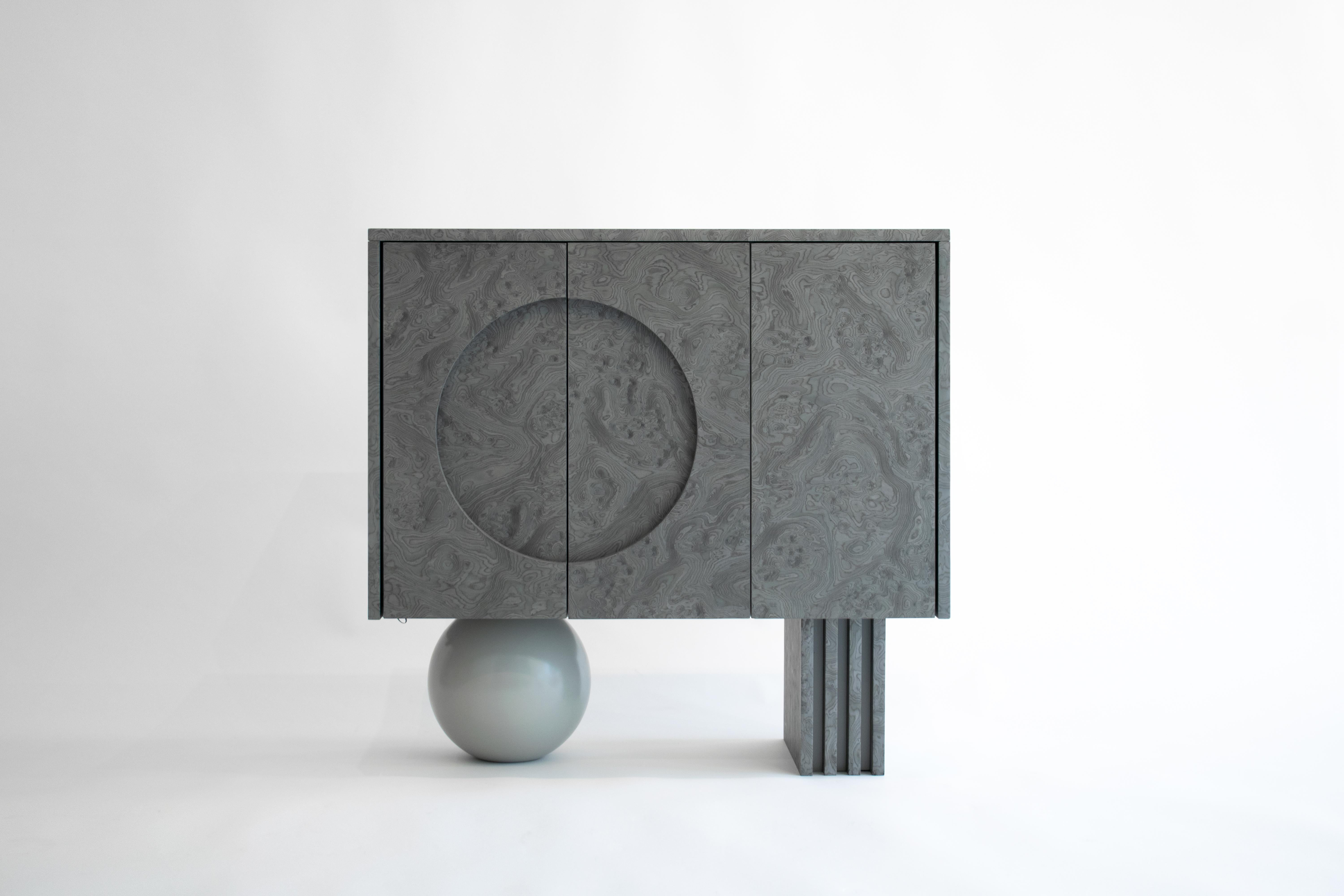 Following the dark tone pieces in the series, this piece takes the shape of a concentrated prism, gently levitating over the base plane. The triple door buffet is covered in ALPI silver veneer, with a subtle engraved moon circle in its left side.