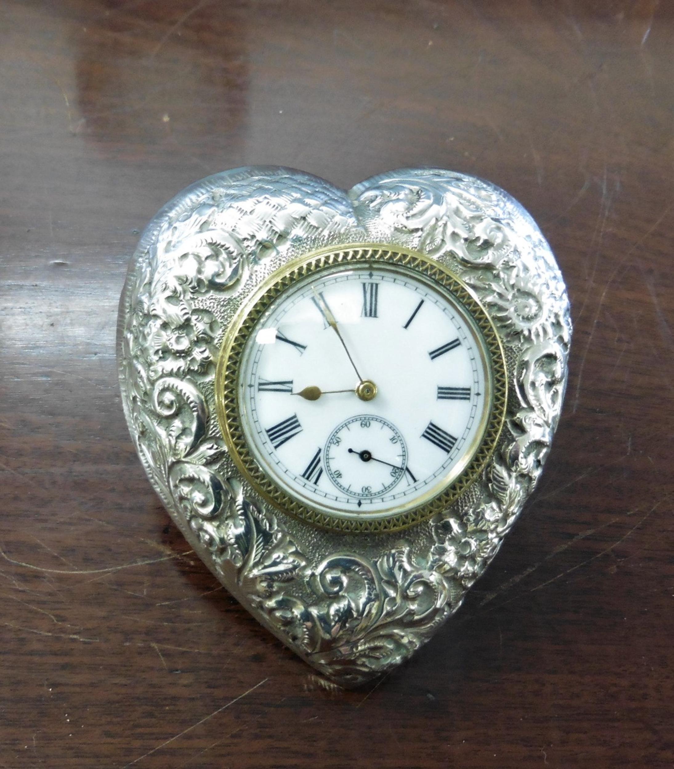 Victorian heart shaped silver strut timepiece with foliate decoration. Brass bezel with hatched decoration, enamel dial with Roman numerals, original gilded hands and a subsidiary dial for seconds at six o’clock. The case hallmarked for Birmingham