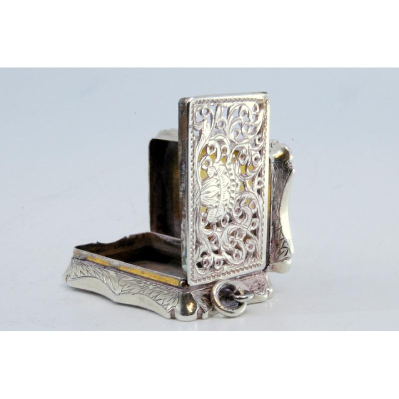 Description: Silver vinaigrette box with Victorian-era engraving on the lid and hanging ring. Metal: Silver. Origin: English. Brand: Birmingham. Weight: 19.73 grams. Dimensions: 3.7x2.5cm. Content: 925/1000. Assay Mark: Yes, 1846 by Francis Clark.
