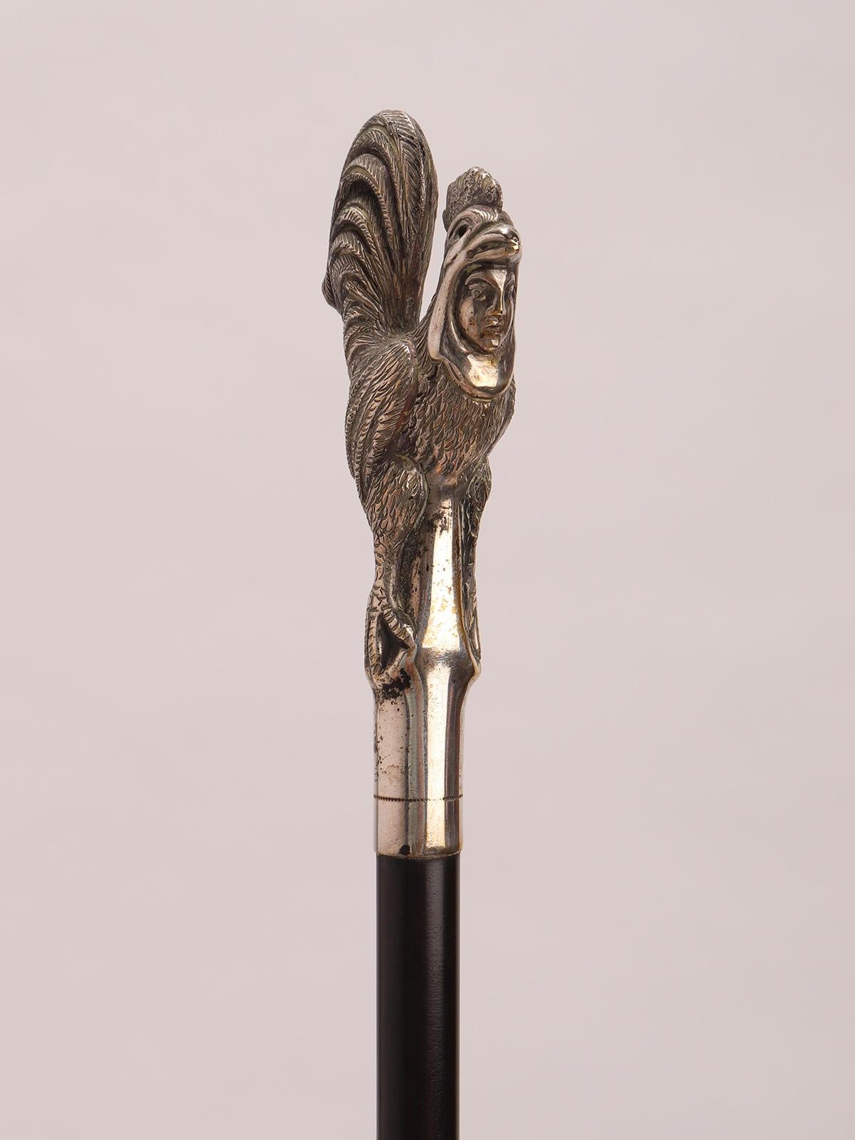 XIX secolo Bastone da passeggio in argento con un gallo con il volto di un uomo, Francia 1890. in vendita