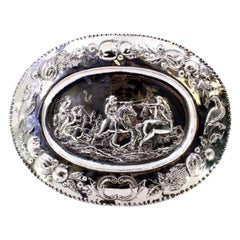 Salvamantel de plata con escena de batalla, monograma y relieve ornamentado