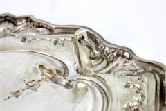 Silver wall tray with floral reliefs revealing a monogram card