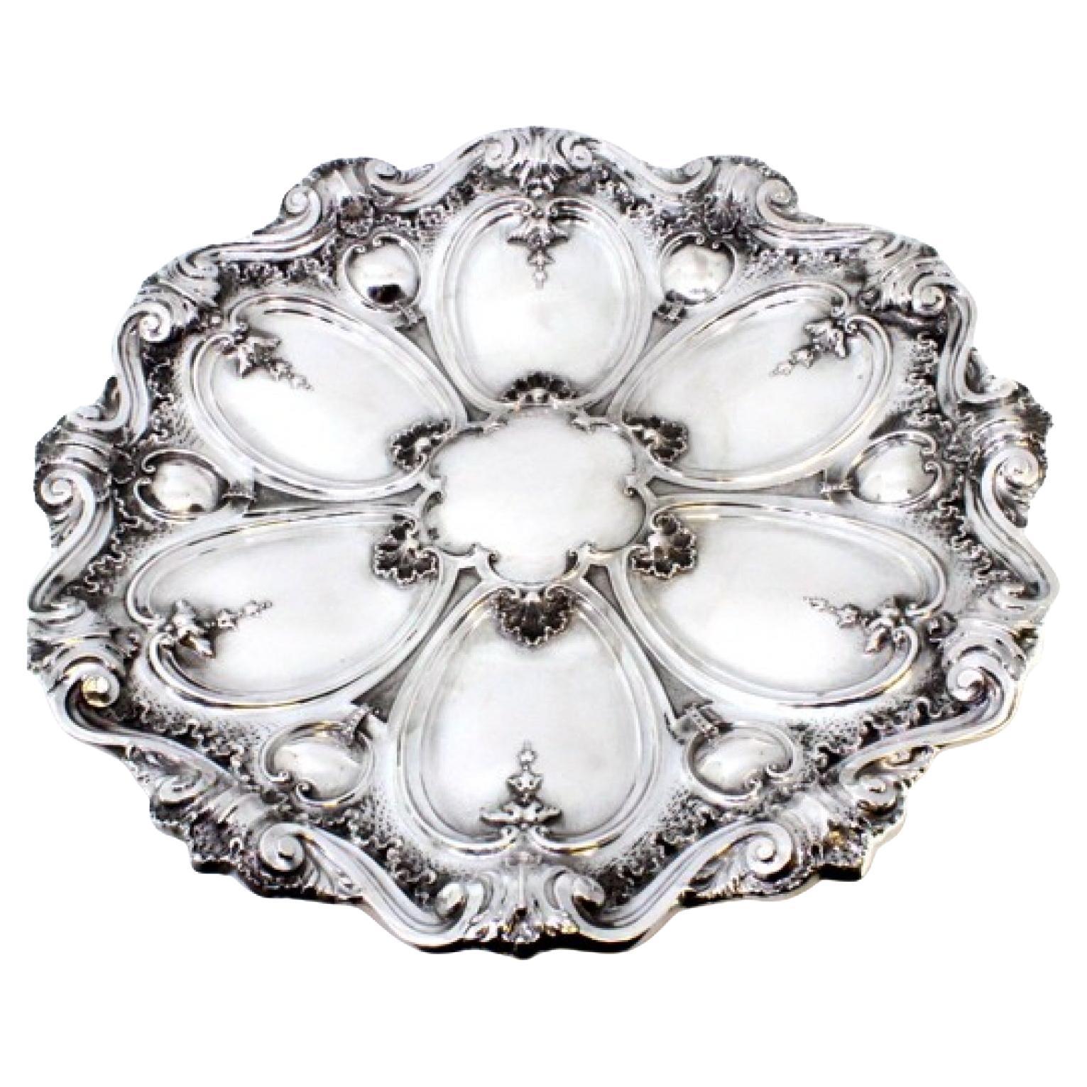 Silver wall tray with floral reliefs revealing a monogram card
