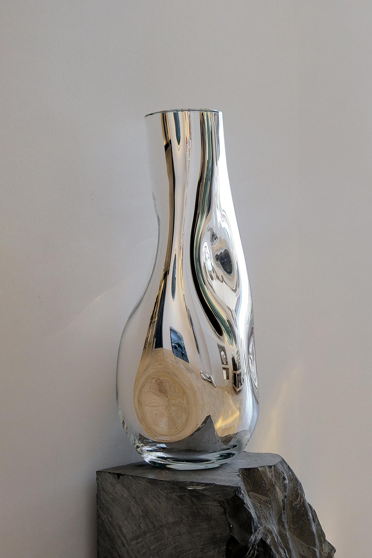 Vaso Silver Wave II di Homa
Dimensioni: L 22 x P 20 x H 50 cm
Materiali:  Vetro soffiato. Silver Mirror. 

HOMA è un atelier di design contemporaneo con sede a Istanbul. I processi caratteristici dell'Atelier sono il vetro soffiato a mano, la