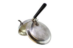 Silver whisk w/ floral-engraved lid, 3 raised feet & wooden handle