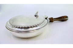 Silver whisk with raised trim on the lid and wooden handle