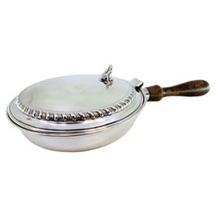 Silver whisk with raised trim on the lid and wooden handle