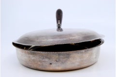 Silver whisk with wooden handle and fish-shaped knob on the lid