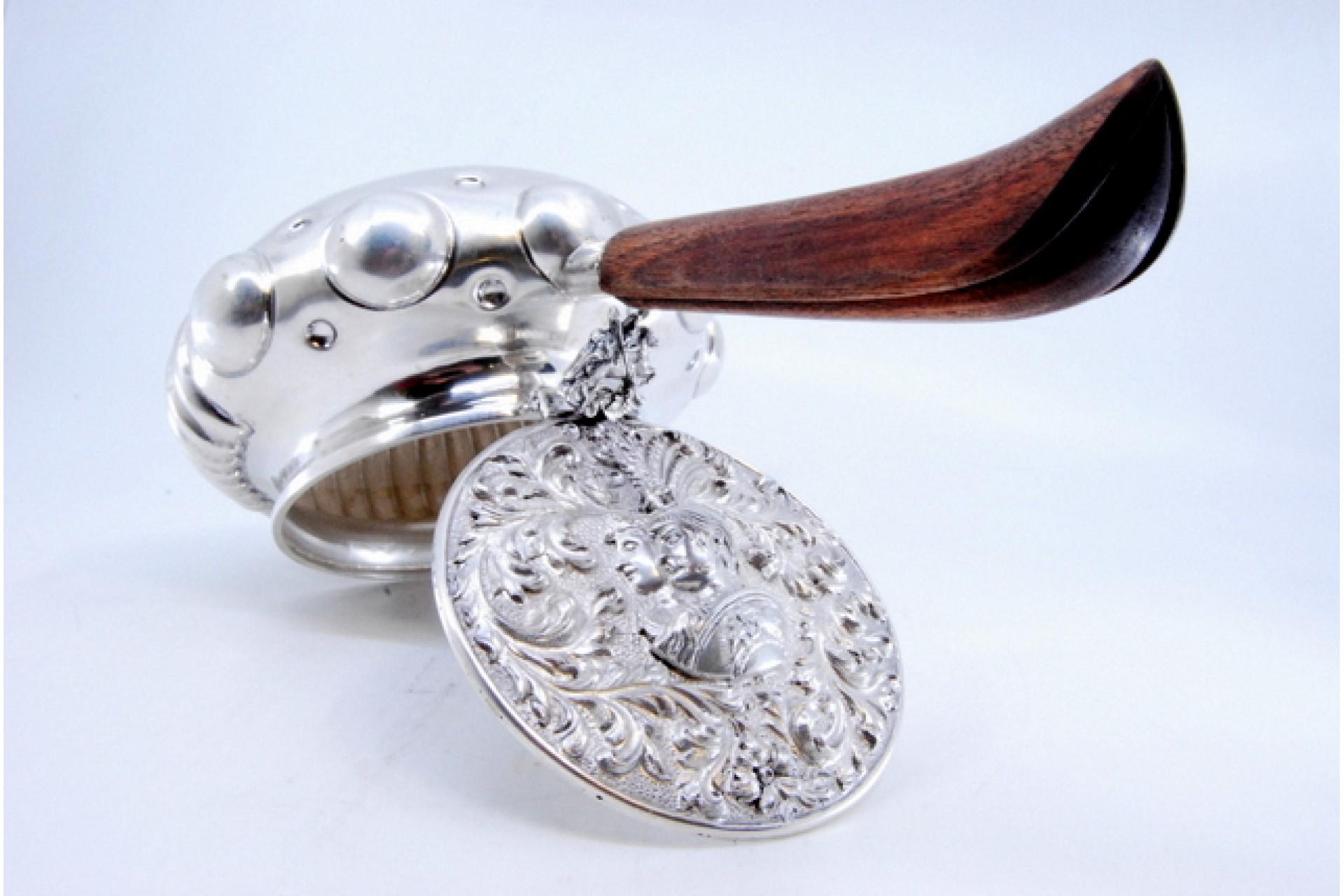 Description : Porte-cigarettes en argent avec poignée en bois, couvercle estampé et réservoir cannelé. Métal : Argent. Origine : Portugais. Marque : Aigle debout. Poids : 416,55 g. Dimensions : 24 x 9,5 cm : 24x9.5cm. Contenu : 833/1000. Marque