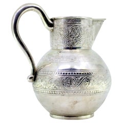 Silver wine jug engraved w/ bunches of grapes
foliage, set on a circular base