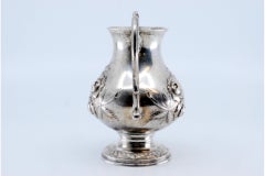 Silver wine jug with engraved floral motifs surrounding a monogram card