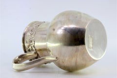 Silver wine jug with grape and leaf reliefs on smooth body