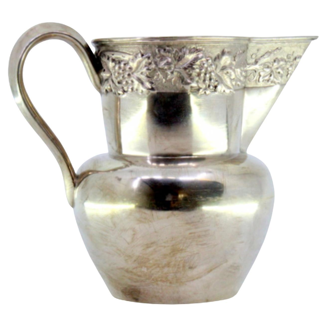 Silver wine jug with grape and leaf reliefs on smooth body
