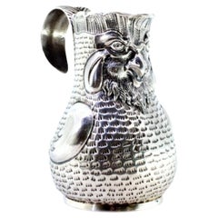 Silver wine jug with rooster-shaped reliefs