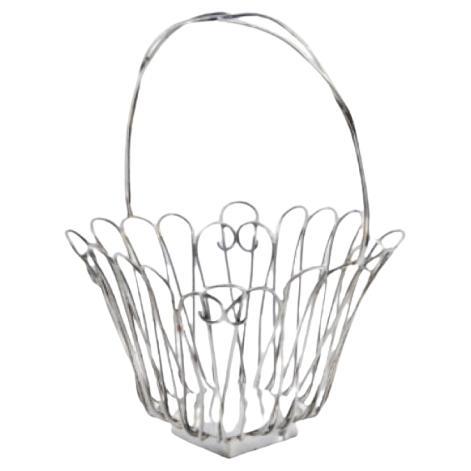 Silver wire basket with hinged handle and resting on a square base