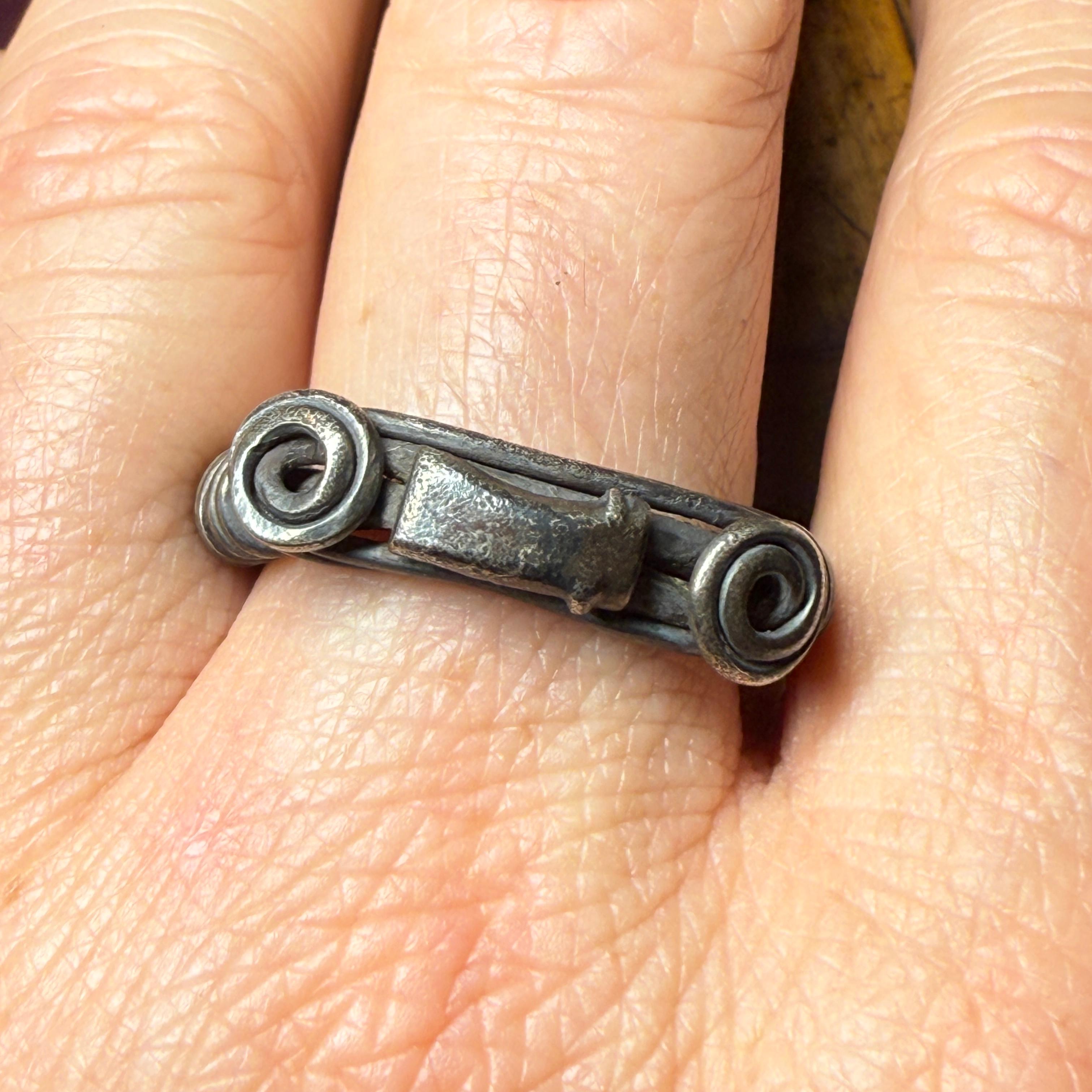 Silver Ring with Spiralled Terminals and Axe-Motif Ornament
 
Central Balkans (Balkan–Danubian provincial style), 1st–2nd century A.D.
 
Measurements
 
Ring size: UK T ½ / US 9.75 / EU 62
Outer diameter: 2.8 × 2.7 cm
Weight: 8.32 grams
 
