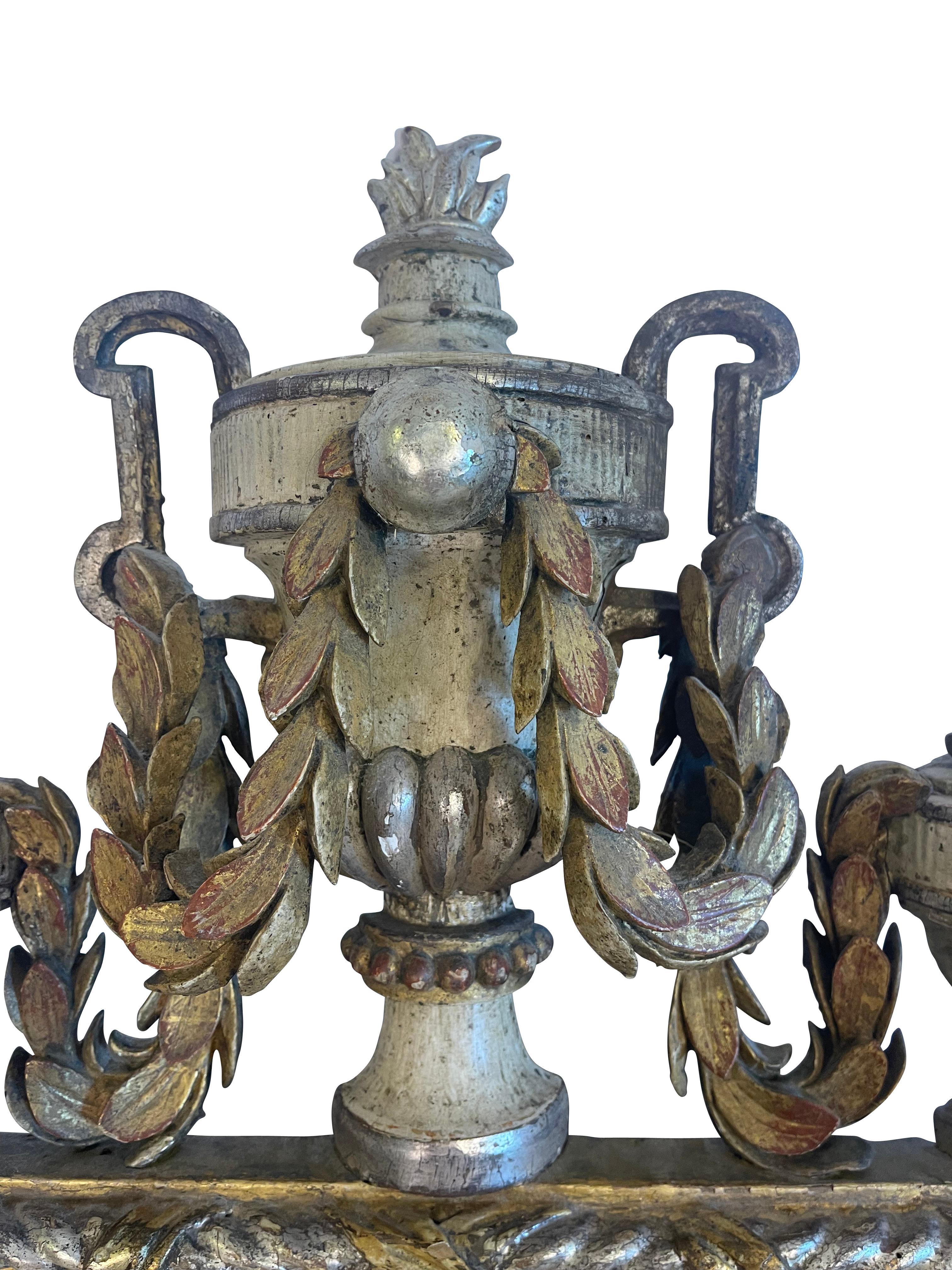 Swedish neoclassical giltwood and silvered mirror with original glass. The mirror is highly decorative, with three carved urns adorning the top of the mirror with laurel swags throughout. The central urn features double handles and a carved flame