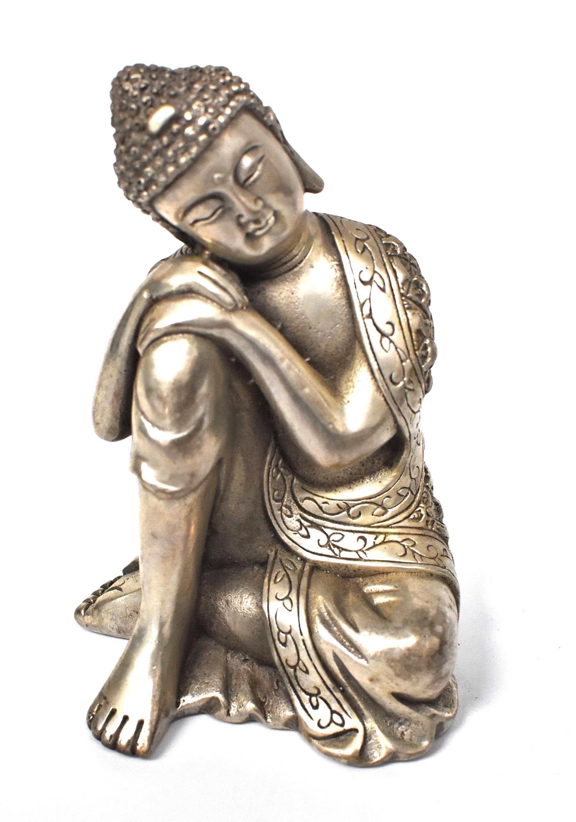 A beautiful silvered brass metal contemplative Buddha. This is a rare version of Buddha depiction, in an unique style. The Buddha wears an elaborately embossed robe, has a full face and long ears. His expression is joyful and serene. Through fine
