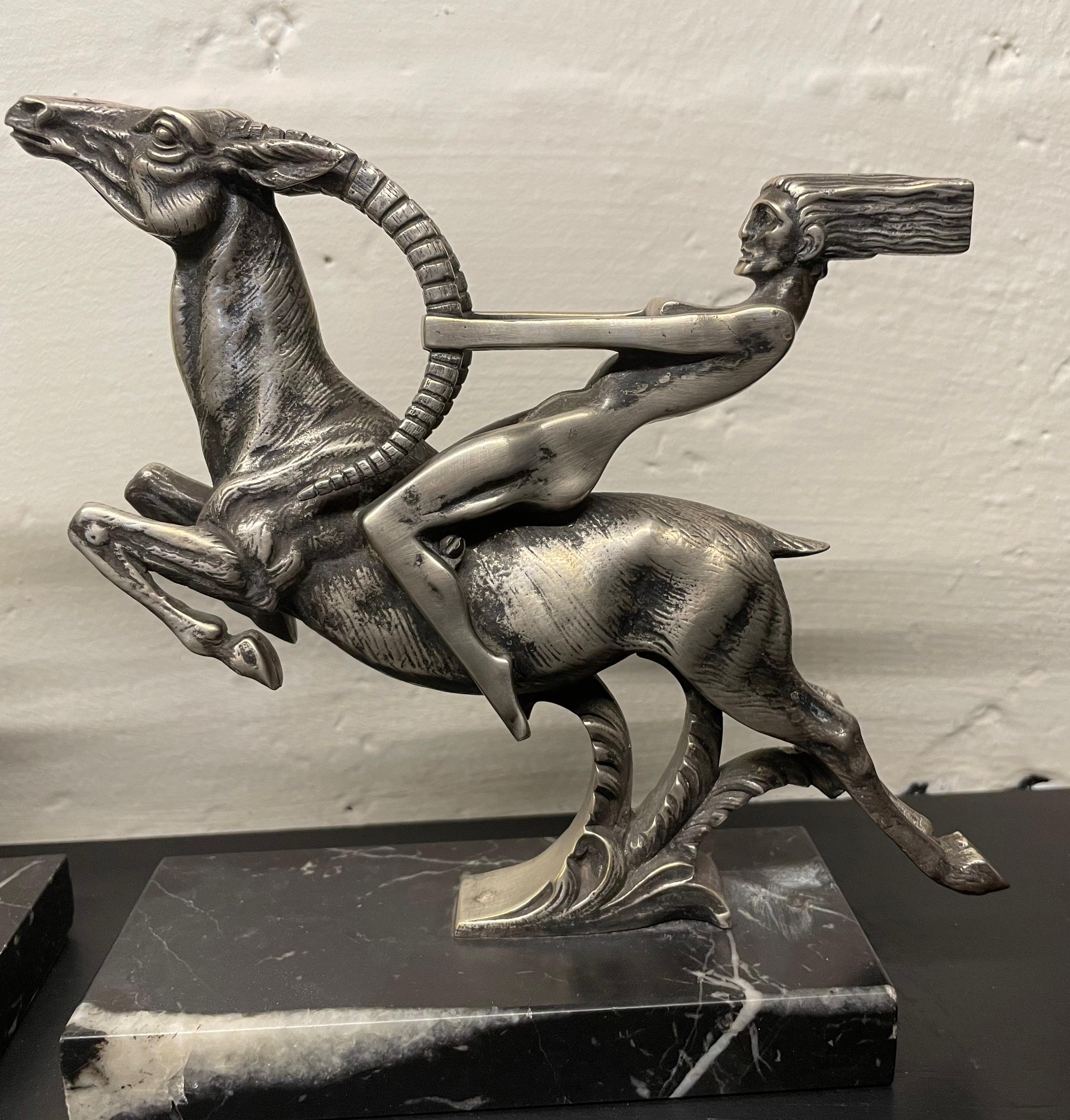 Silvered Bronze Art Deco Statue Pair featuring a woman reaching grasping the antlers of a deer. Designed by Aurore Onu. Outstanding classic and cubist design, female figure flowing and blowing hair riding the magic horse (or is it a gazelle?) The