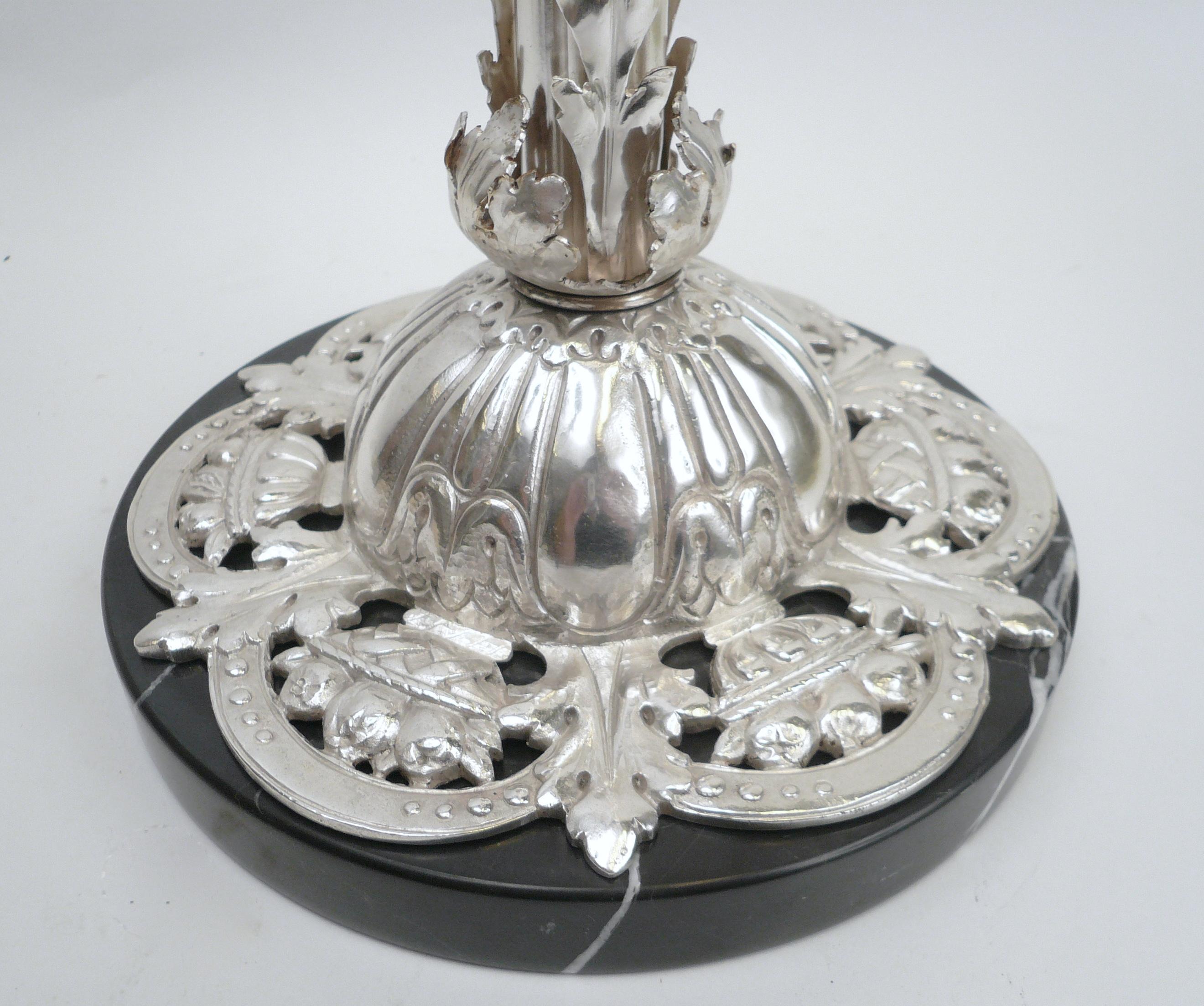 Cette jolie lampe de table en bronze moulé et martelé à la main présente des motifs feuillus et une base florale percée.