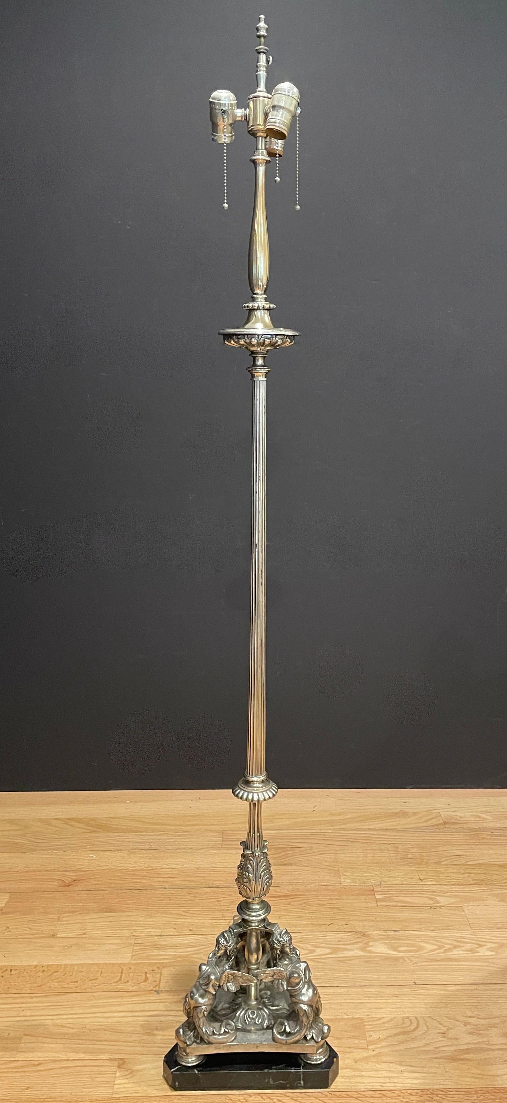 Italian Renaissance style bronze floor lamp. Torchiere form lamp in Grand Tour style Circa 1900, baluster shaft with mermaid and amorini decorations, tripod mermaid and swag legs, raised on triangular shaped black marble plinth,.