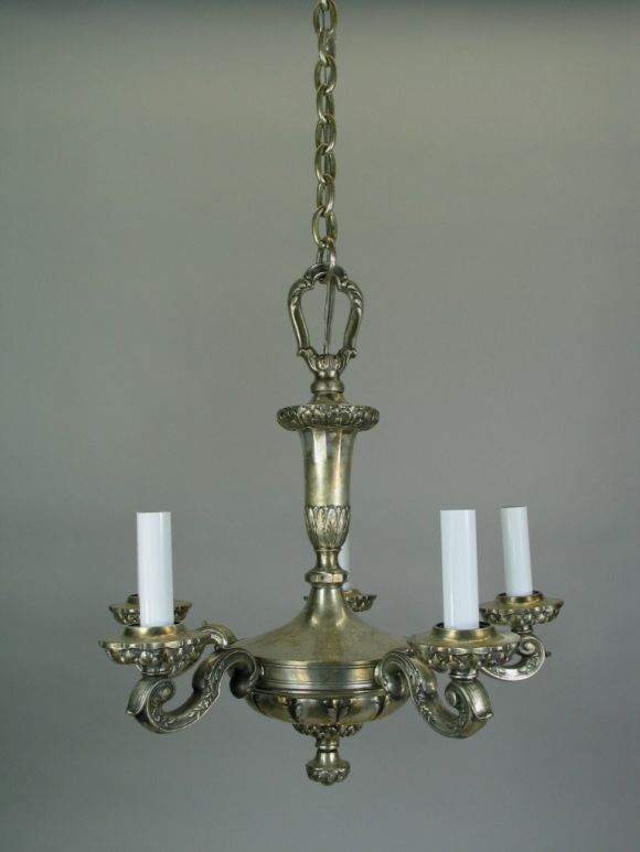 Five-light chandelier has a silver plated finish.
The heavily scrolled arms radiate from an ornately cast center piece.
 
