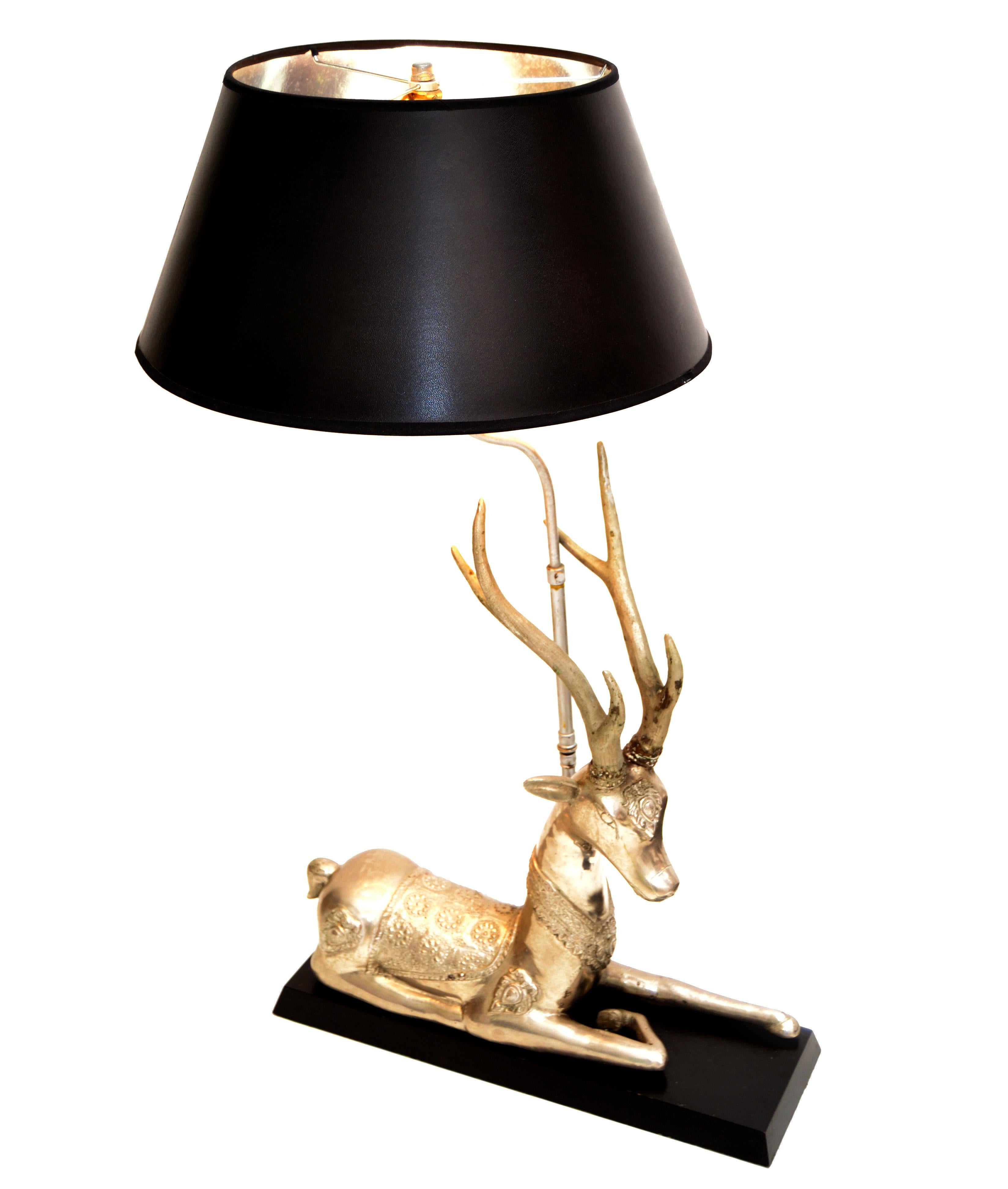 Graceful resting hand-carved silvered brass deer lamp mounted on a black lacquered wooden base.
Detailed on back and Head with extraordinary carvings.
In perfect working condition and takes 1 regular or LED bulb. 
Comes with black & silver paper