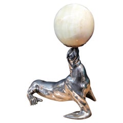 Bronzo argentato illuminato  Scultura raffigurante una foca che tiene in mano una palla di onice