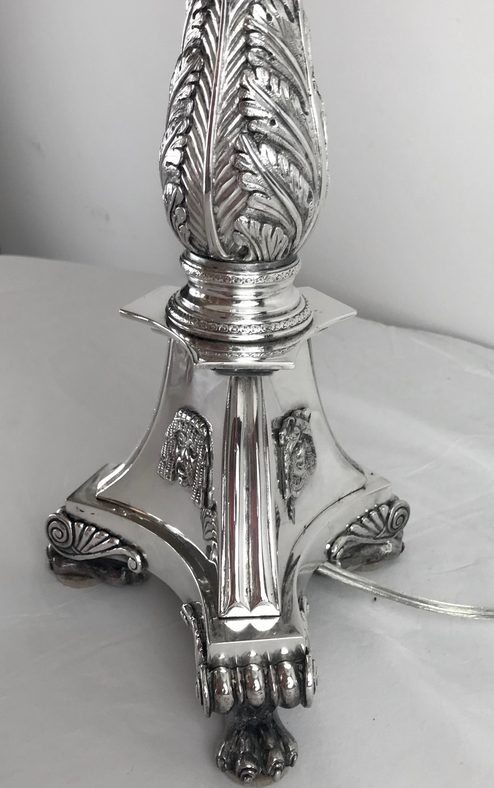 This finely cast bronze table lamp features Classical motifs including acanthus leaves. The tapering fluted columnar shaft rests on a triangular plinth base with hairy paw feet.