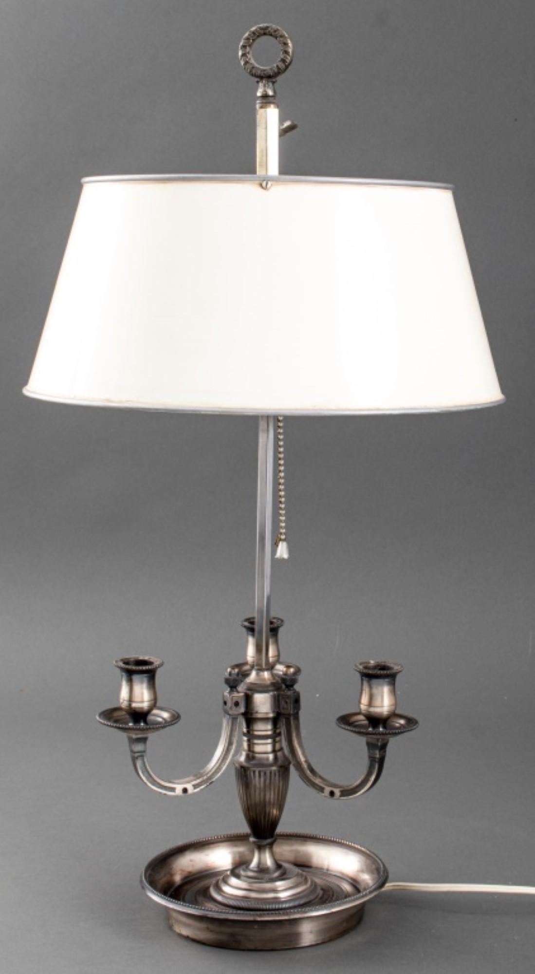 A Timeless Illumination: Silvered Bronze Three-Light Bouillotte Lamp
This exquisite 20th-century lamp embodies sophisticated elegance. Crafted from gleaming silvered bronze, it features three graceful arms that arch upwards, reminiscent of delicate