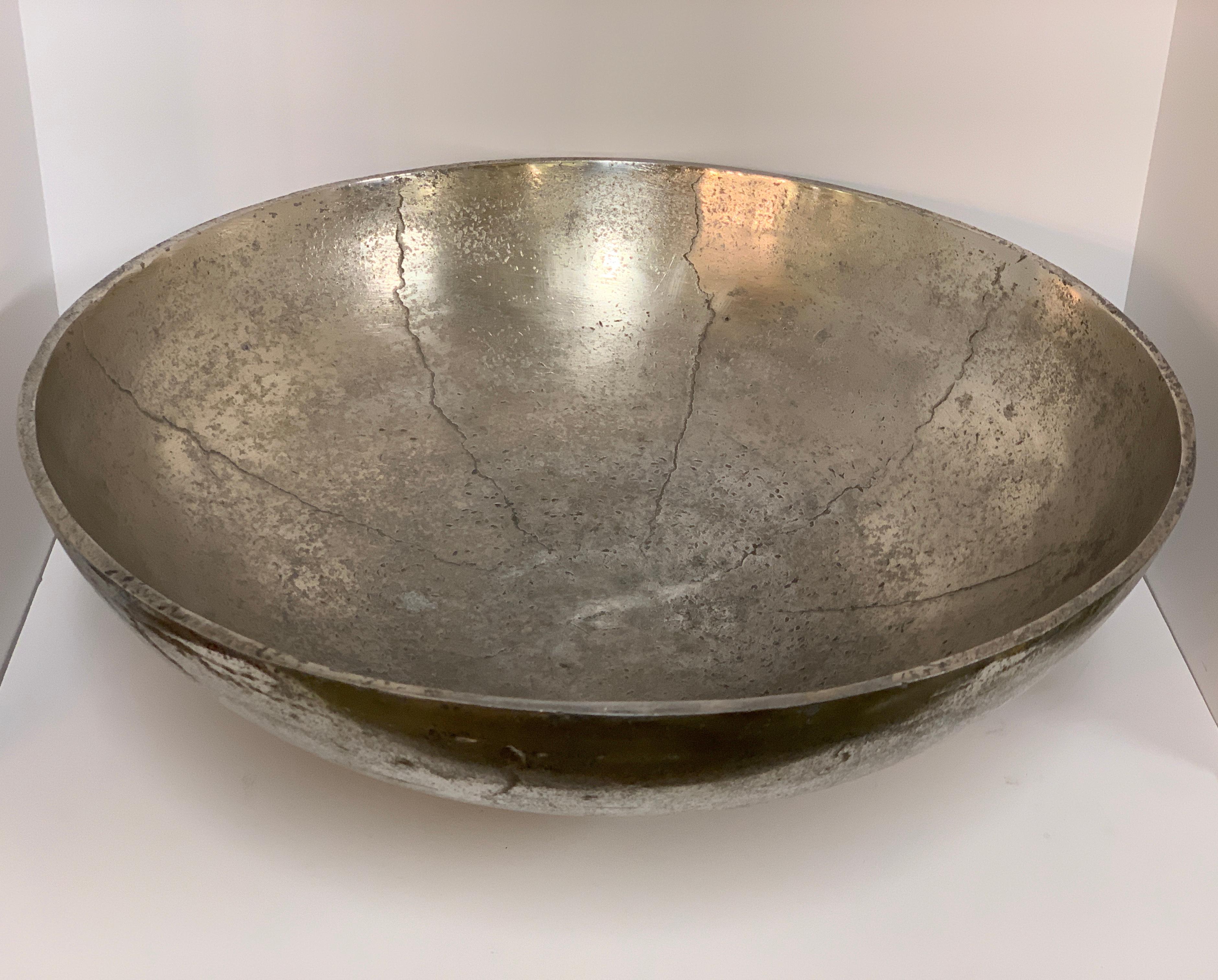 A quite impressive and massive large bowl we had a base made for. We believe the metal may be some of silver plate as it has a silver smell when rubbed. It could be pewter as well the way it is cracked during the casting. In any event a beautiful