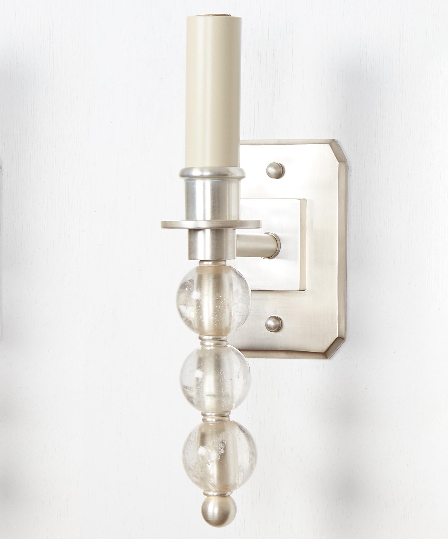 Coppia di appliques Ephorus a una luce personalizzate con finitura argentata e tre sfere di cristallo di rocca e piastre posteriori rettangolari con bordi smussati. Venduti in coppia ma acquistabili anche singolarmente. Ogni applique ha una presa a