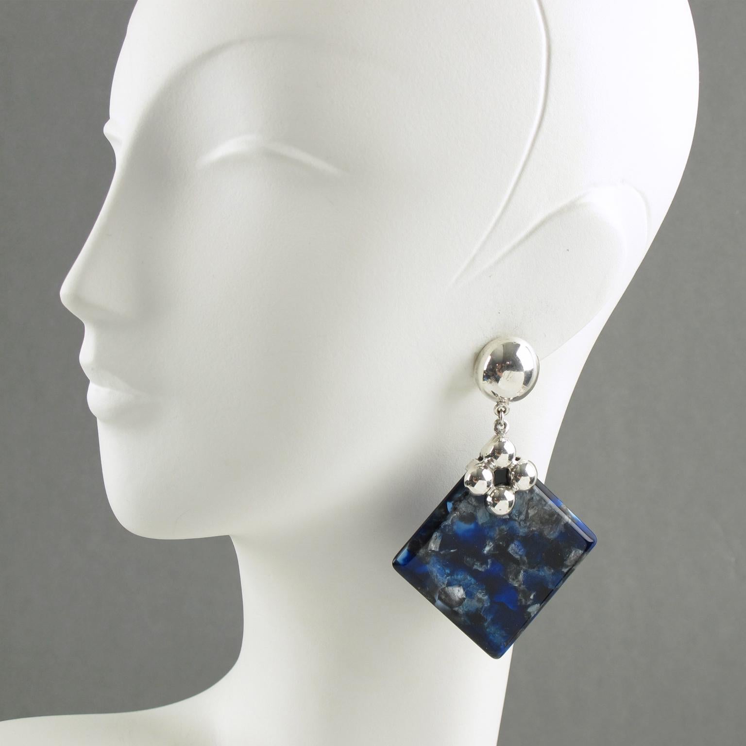 Graziosi orecchini a clip in argento e lucite. La fibbia e la ferramenta in argento lucido sostengono uno spesso pezzo geometrico di resina di un incredibile colore blu elettrico, nero e grigio con una trama perlata. Non c'è alcun marchio visibile