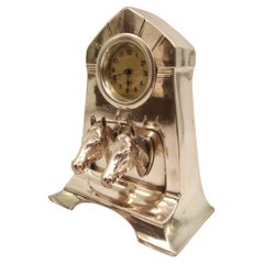Reloj de sobremesa plateado con dos cabezas de caballo. La década de 1910 en Alemania