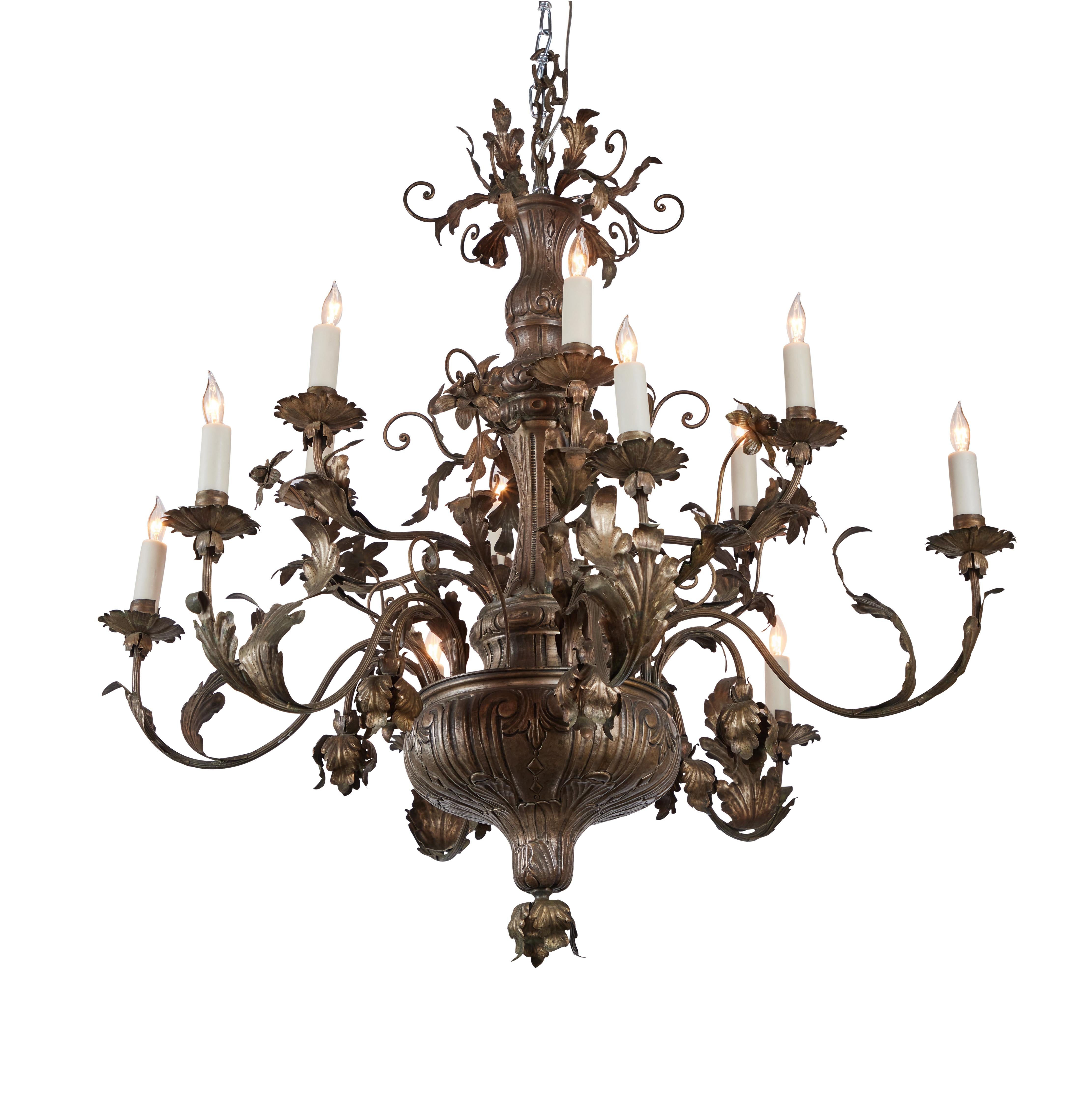 Hand pounded and cut silvered tole, 12 light chandelier from the area of Florence. Floral and foliate decoration with wax candle sleeves. Wired for US.