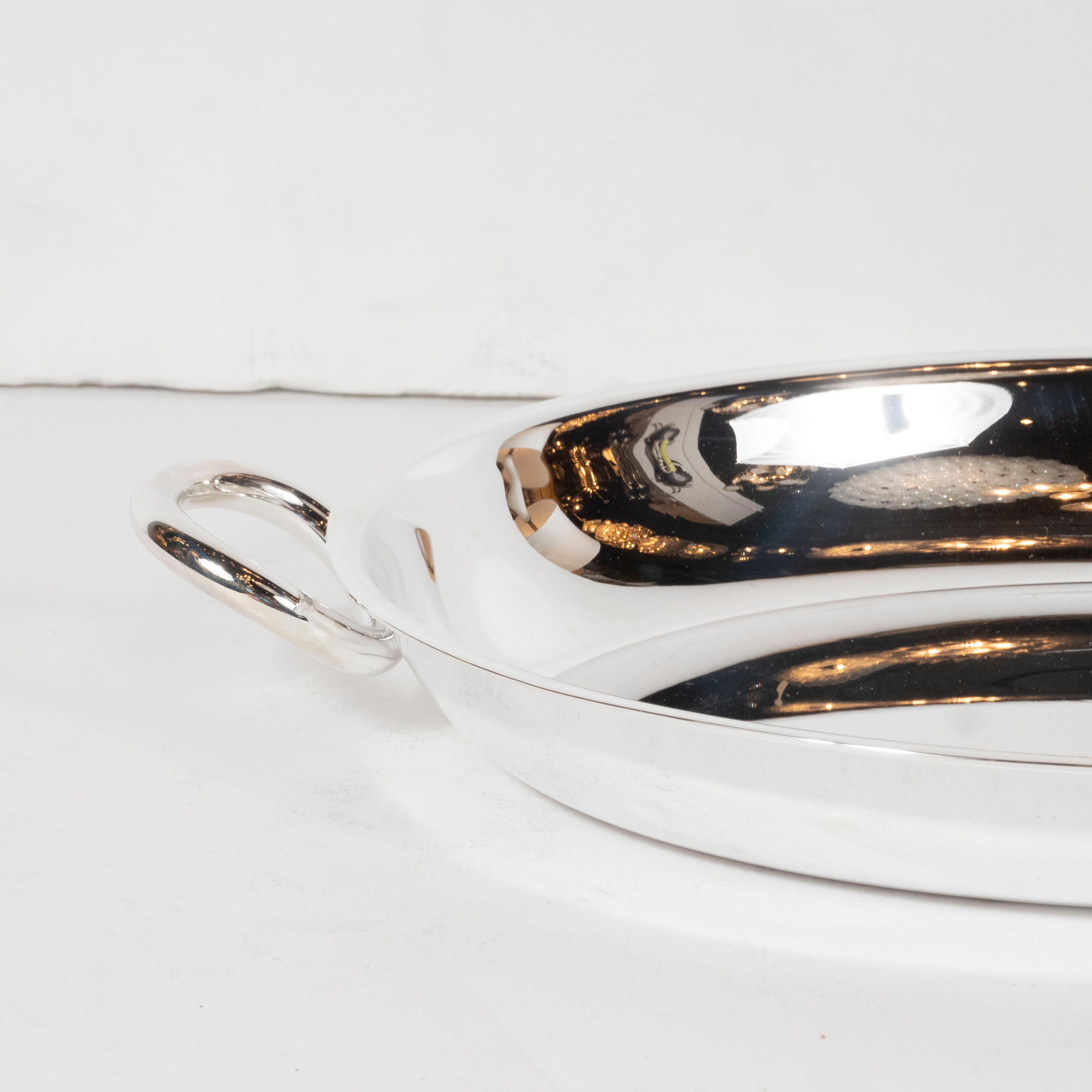 This refined modernist silver plated hors serving platter, perfect for presenting olives, nuts or any other delicacy, was realized by Christofle in France. Part of their Vertigo Pattern series, the piece a recessed centers and two circular handles